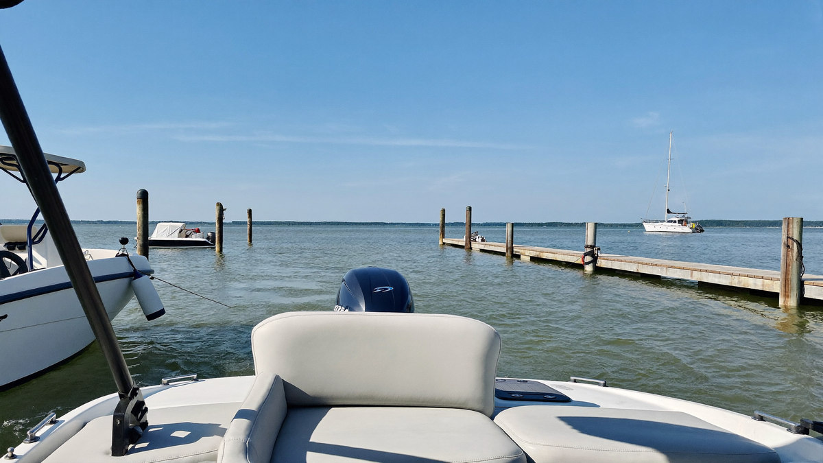 Pontoon boat idling out of a marina no-wake zone onto open water