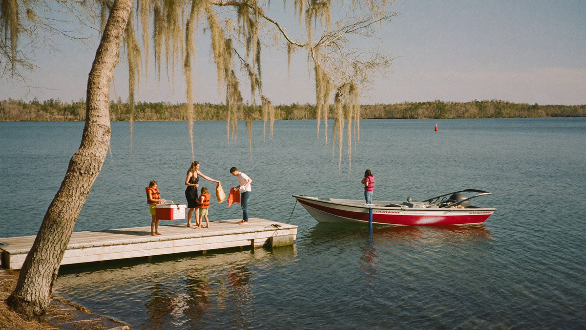 Family loading a boat at a Lake Moultrie marina dock under Spanish moss