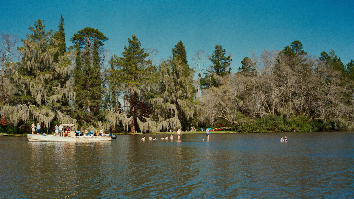 Pontoon boat and swimmers in a Lake Moultrie cove on a late summer holiday weekend