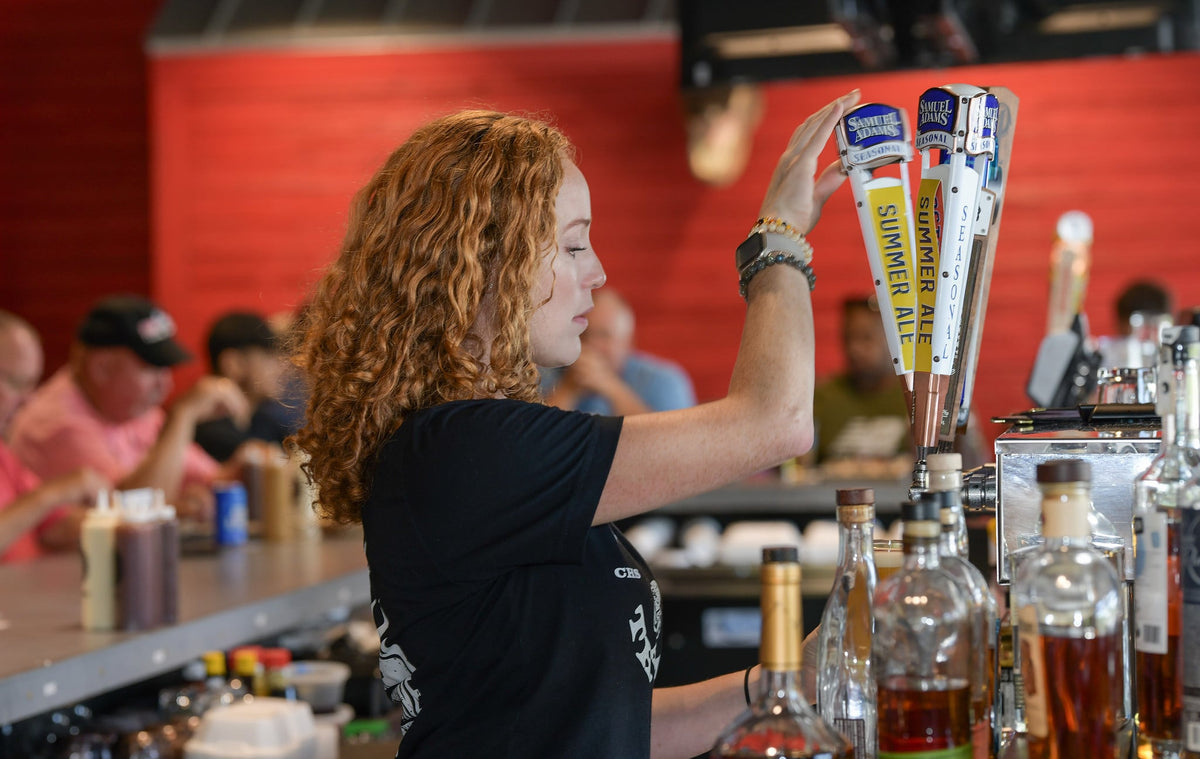 Bartender pulling a draft beer at Swig and Swine