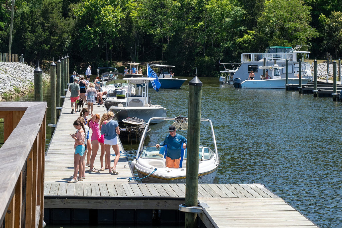 Family walking the dock as a boat pulls in at Hidden Cove Marina