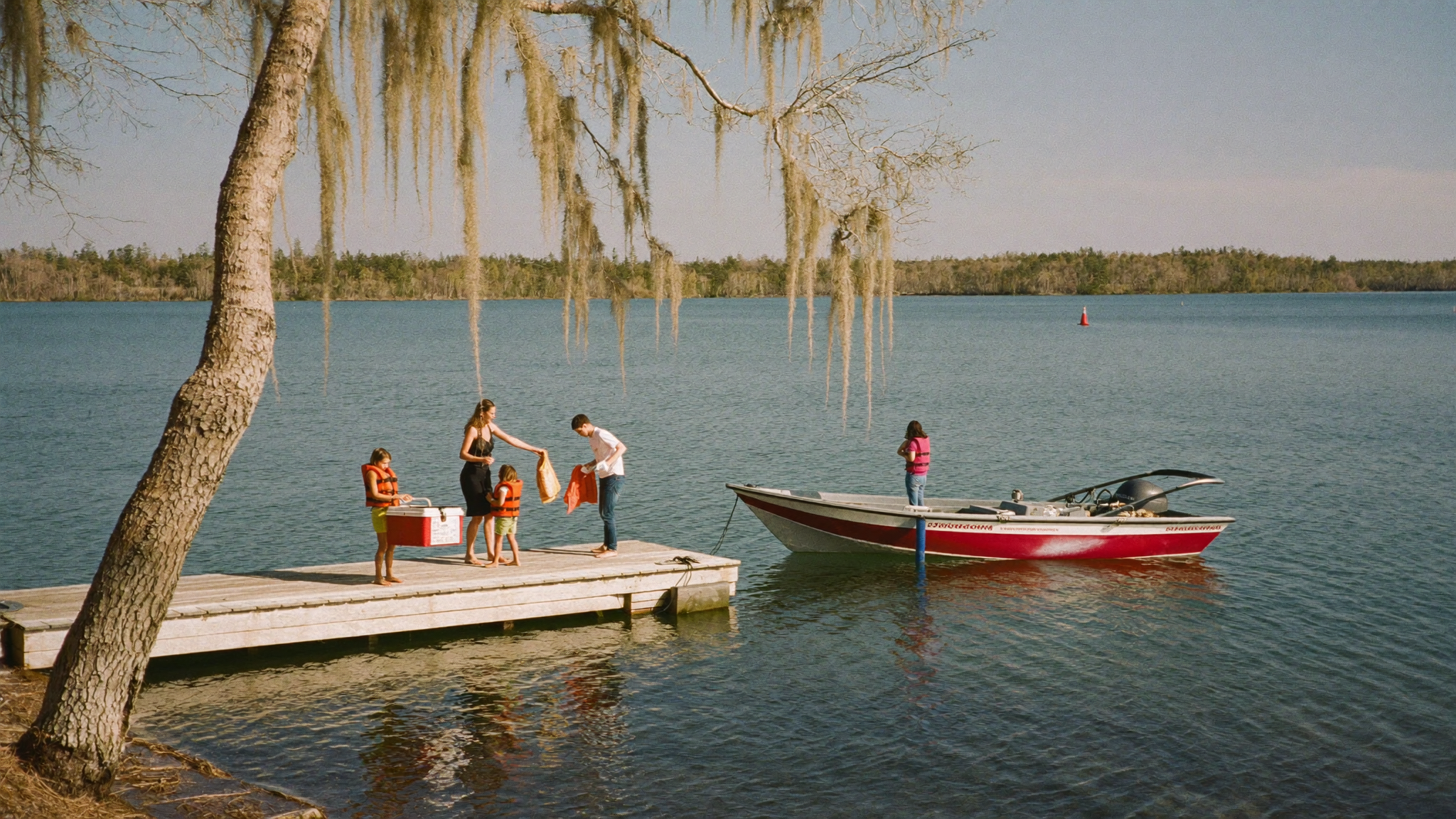 Family loading a boat at a Lake Moultrie marina dock under Spanish moss
